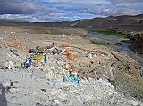 Tibet Kailash 06 Tirthapuri 11 View From Pass On Kora After the hot springs the trail climbs past a cremation area consecrated to Yeshe Tsogyal, and then reaches a miniature version of Kailash's D�lma La, marked with mani stones, prayer flags and a large collection of yak horns and skulls. To the left is the end of a recently constructed over 200m long mani wall, which points to the northeast directly towards Mount Kailas. The wall was the end result of a demon firing an arrow at the guru. He stopped the arrow's flight and transformed it into this wall.